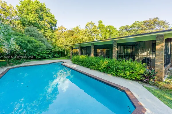 a view of a house with swimming pool next to a yard