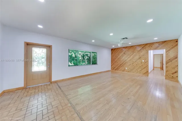 a large kitchen with stainless steel appliances a large counter top a refrigerator and a sink