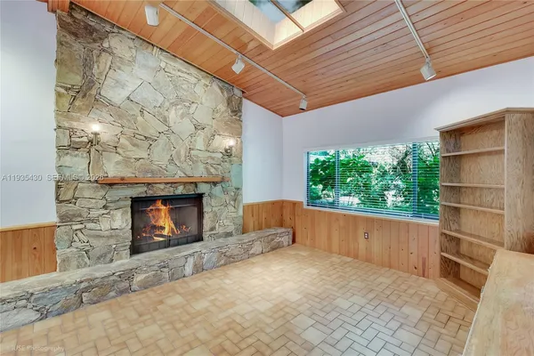 a view of an empty room with a fireplace and a window