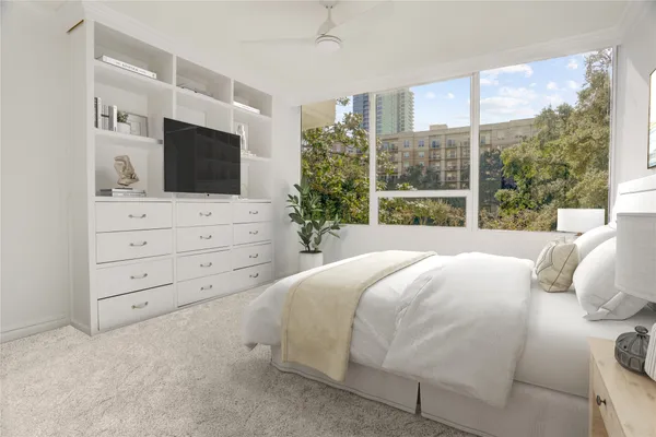 a bedroom with a large bed and a flat tv screen on dresser