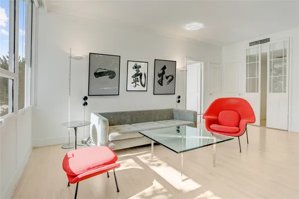 a living room with furniture a rug and a wall painting