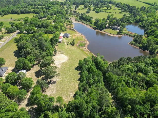 an aerial view of a house with a yard and lake view