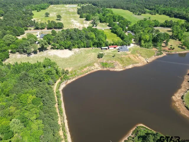 an aerial view of a house with a yard and lake view
