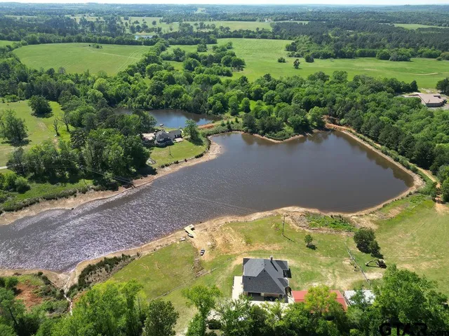 an aerial view of a house with a yard and lake view