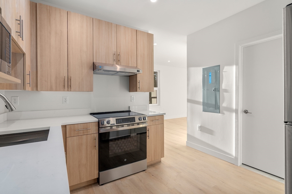1151 Walnut Street, Unit 207 Newton, MA 02461 - Photo 23 of 27 a kitchen with a stove and a cabinet