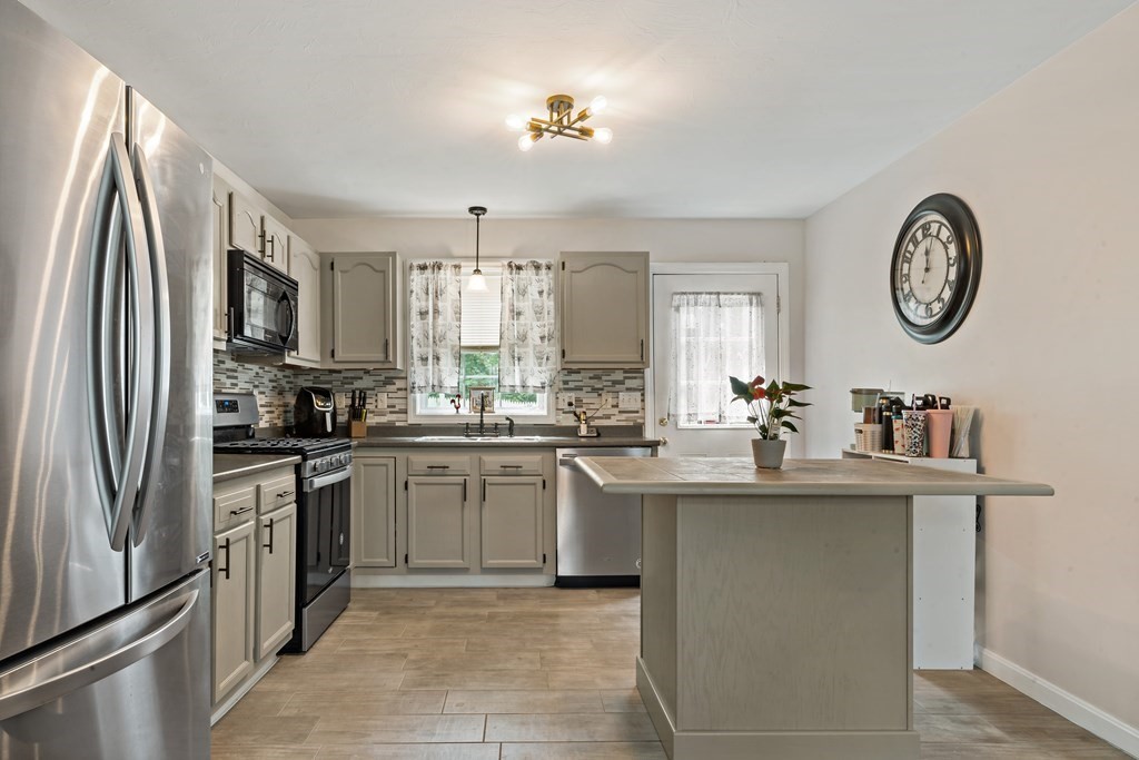 29 Florence Street Fall River, MA 02720 - Photo 5 of 34 a kitchen with stainless steel appliances granite countertop a sink and a refrigerator