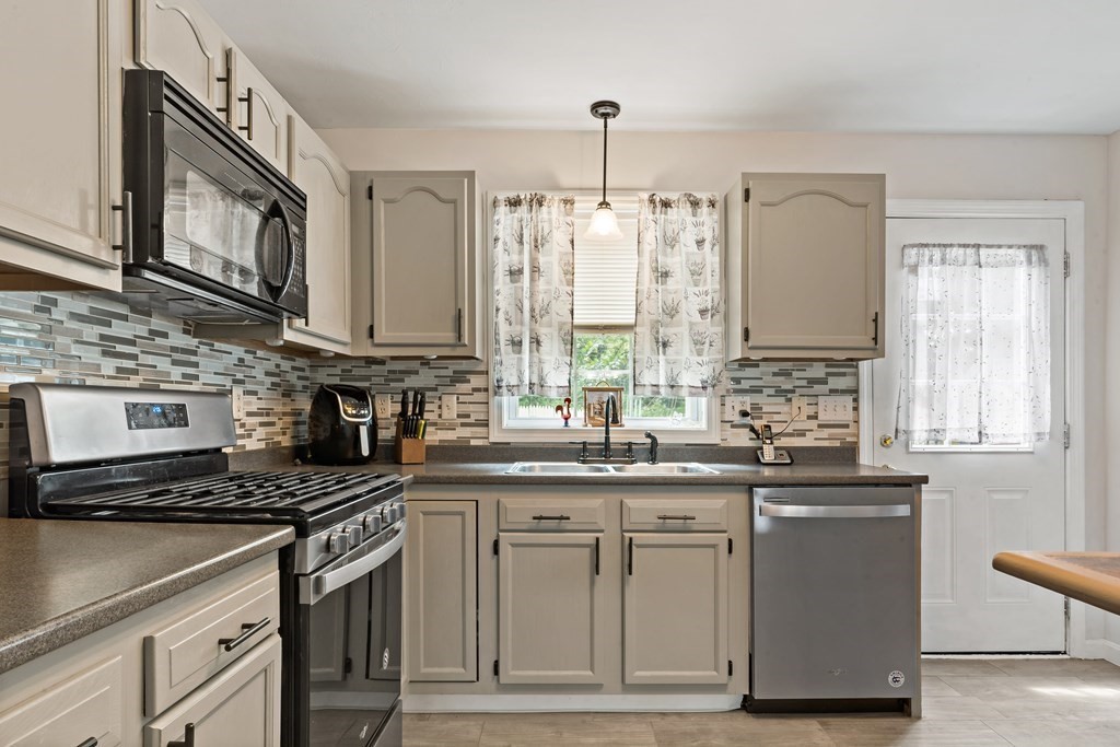 29 Florence Street Fall River, MA 02720 - Photo 6 of 34 a kitchen with stainless steel appliances granite countertop a sink a stove and a microwave