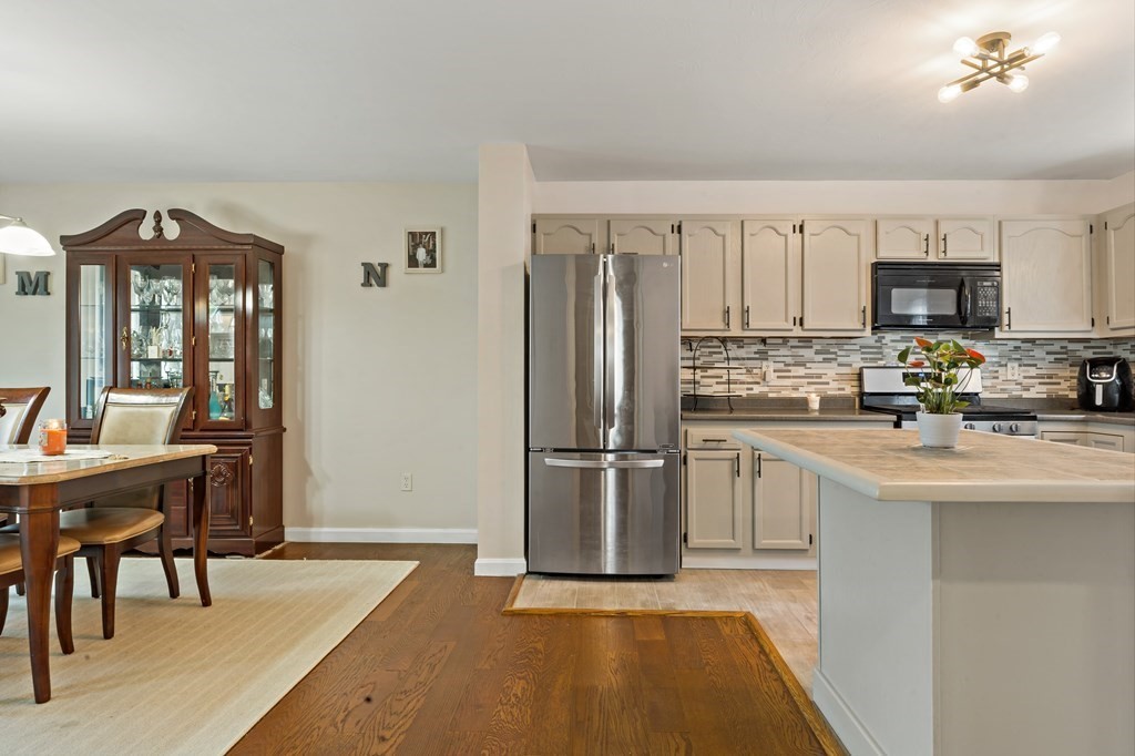 29 Florence Street Fall River, MA 02720 - Photo 10 of 34 a kitchen with kitchen island a refrigerator and a stove top oven