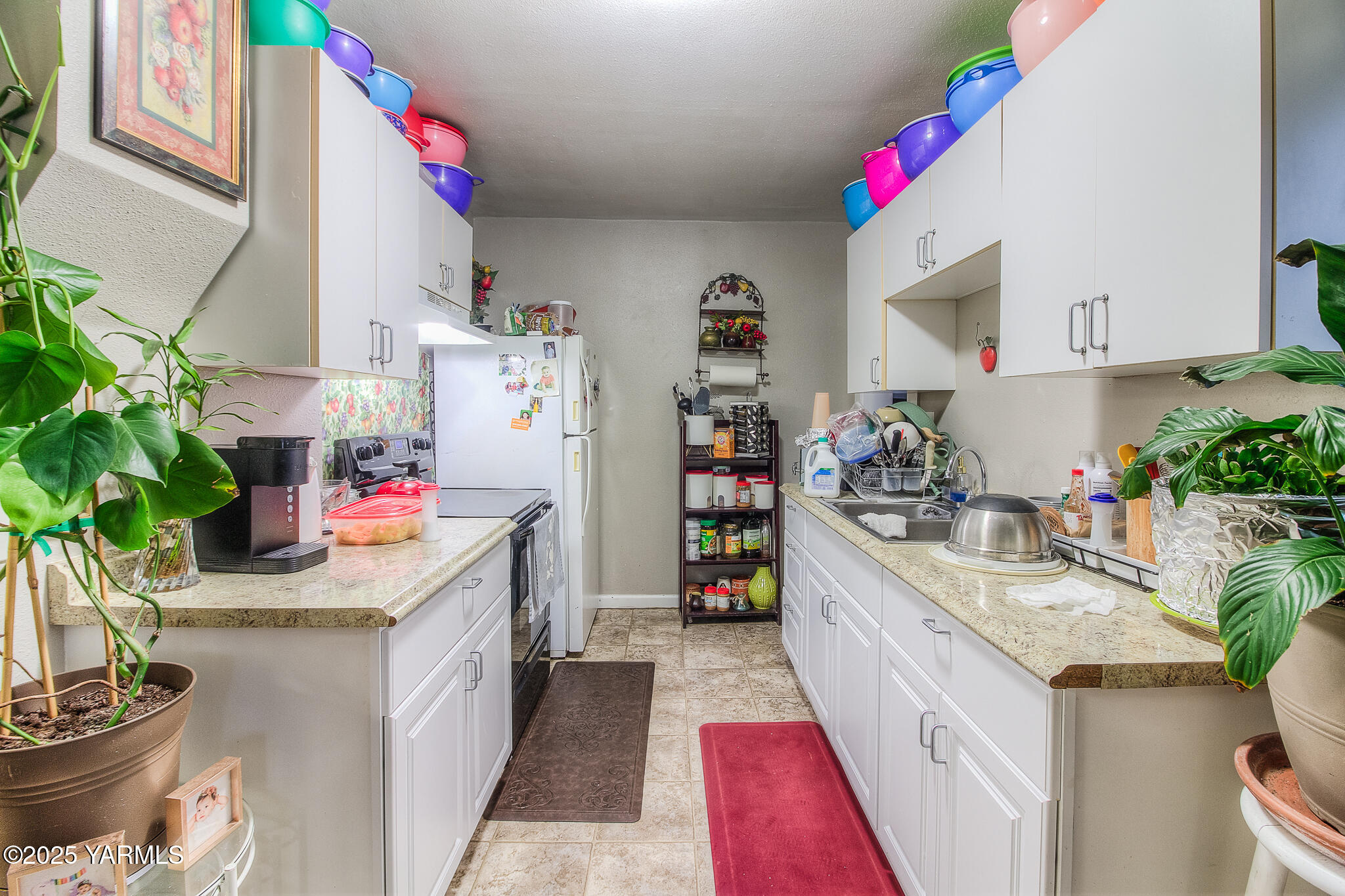 423 Wine Country Road Grandview, WA 98930 - Photo 3 of 14 a kitchen with kitchen island a potted plant on the counter and sink