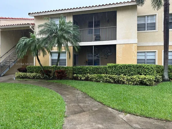 a house with a tree and a yard in front of it
