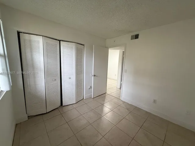 a bathroom with a granite countertop shower a sink and a mirror