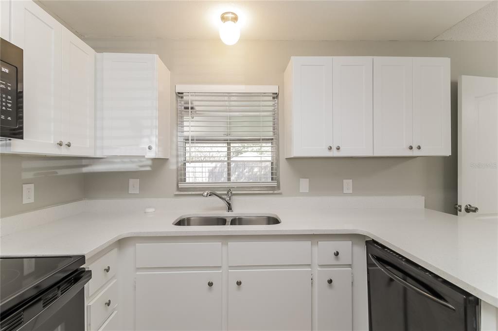 3014 Windchime Circle West Apopka, FL 32703 - Photo 5 of 16 a kitchen with white cabinets and a sink