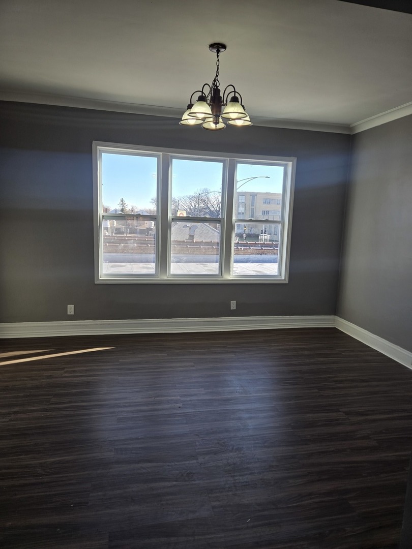 2822 West Marquette Road, Unit 2F Chicago, IL 60629 - Photo 13 of 17 a view of an empty room with wooden floor and a window