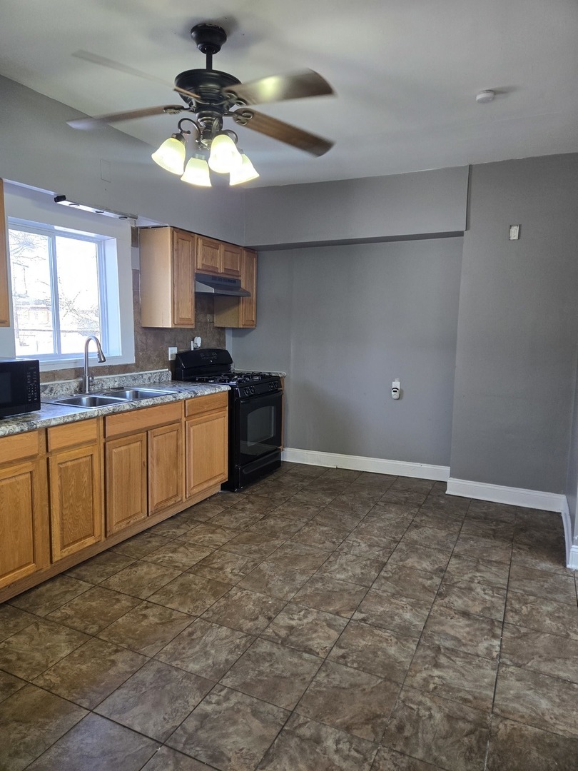2822 West Marquette Road, Unit 2F Chicago, IL 60629 - Photo 15 of 17 a kitchen with granite countertop a sink cabinets and stainless steel appliances