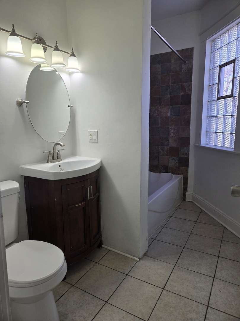 2822 West Marquette Road, Unit 2F Chicago, IL 60629 - Photo 16 of 17 a bathroom with a sink a toilet and bathtub