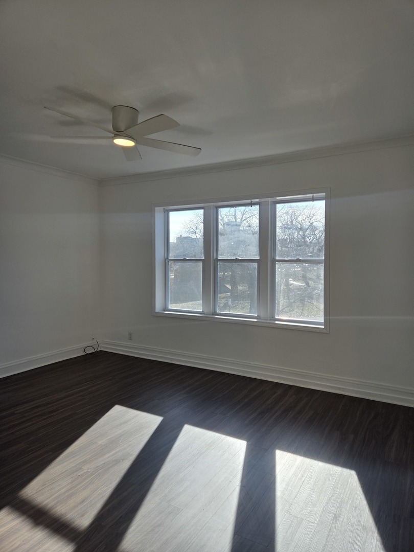 2822 West Marquette Road, Unit 2F Chicago, IL 60629 - Photo 3 of 17 an empty room with wooden floor and windows