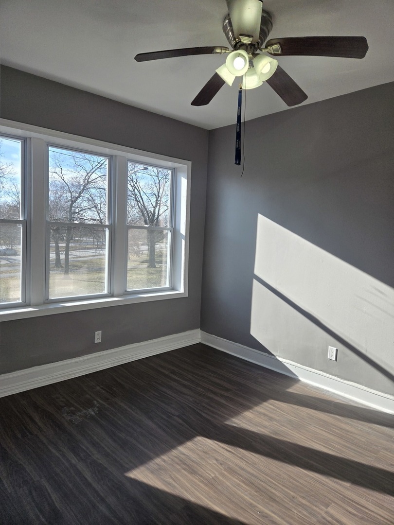 2822 West Marquette Road, Unit 2F Chicago, IL 60629 - Photo 5 of 17 a view of an empty room with wooden floor and a window