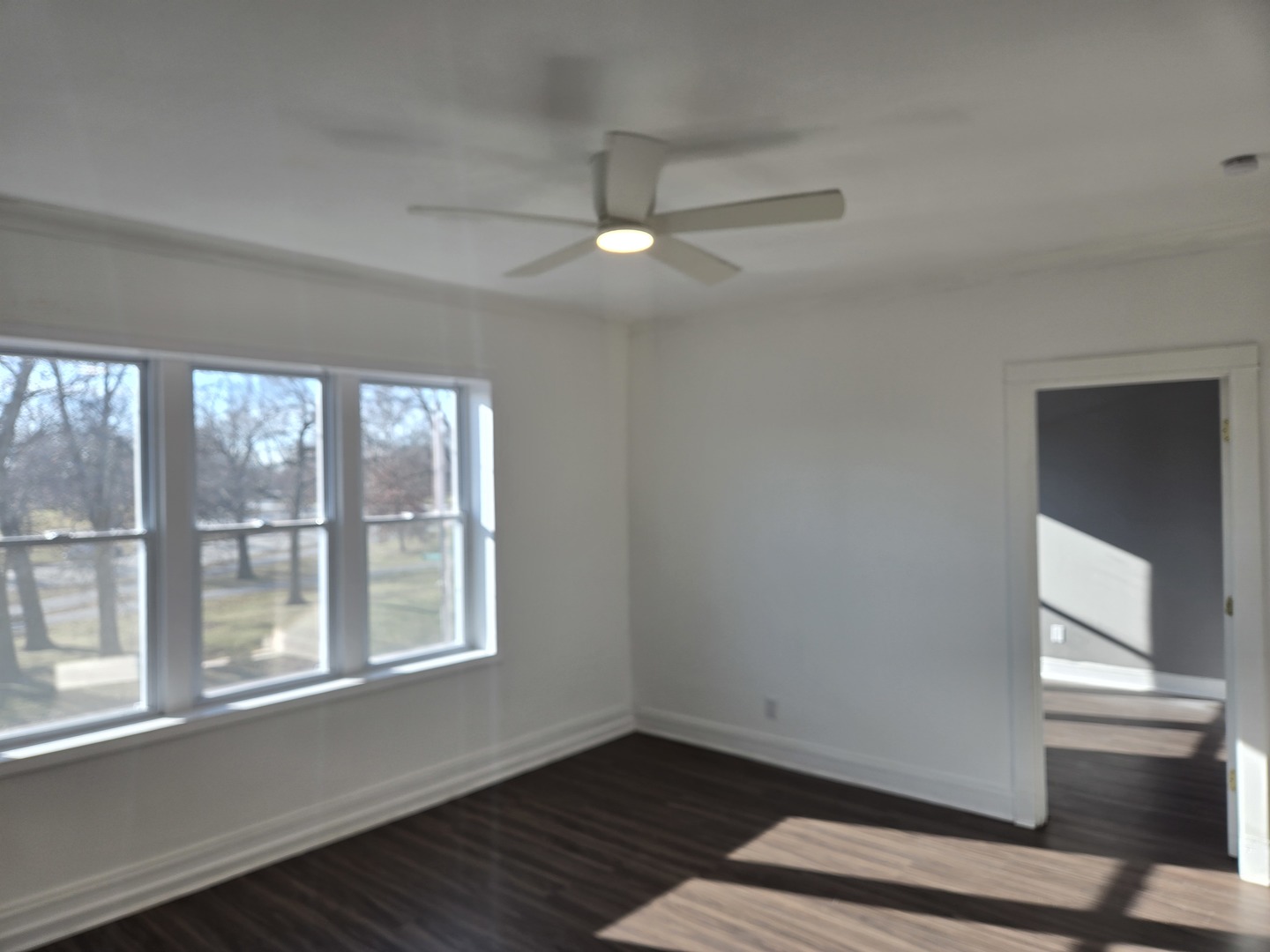 2822 West Marquette Road, Unit 2F Chicago, IL 60629 - Photo 6 of 17 an empty room with wooden floor cabinet and windows