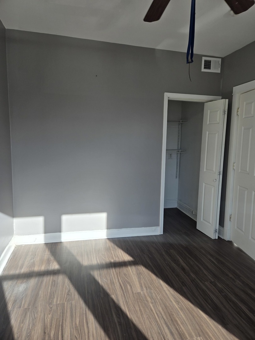 2822 West Marquette Road, Unit 2F Chicago, IL 60629 - Photo 7 of 17 a bedroom with a bed and wooden floor