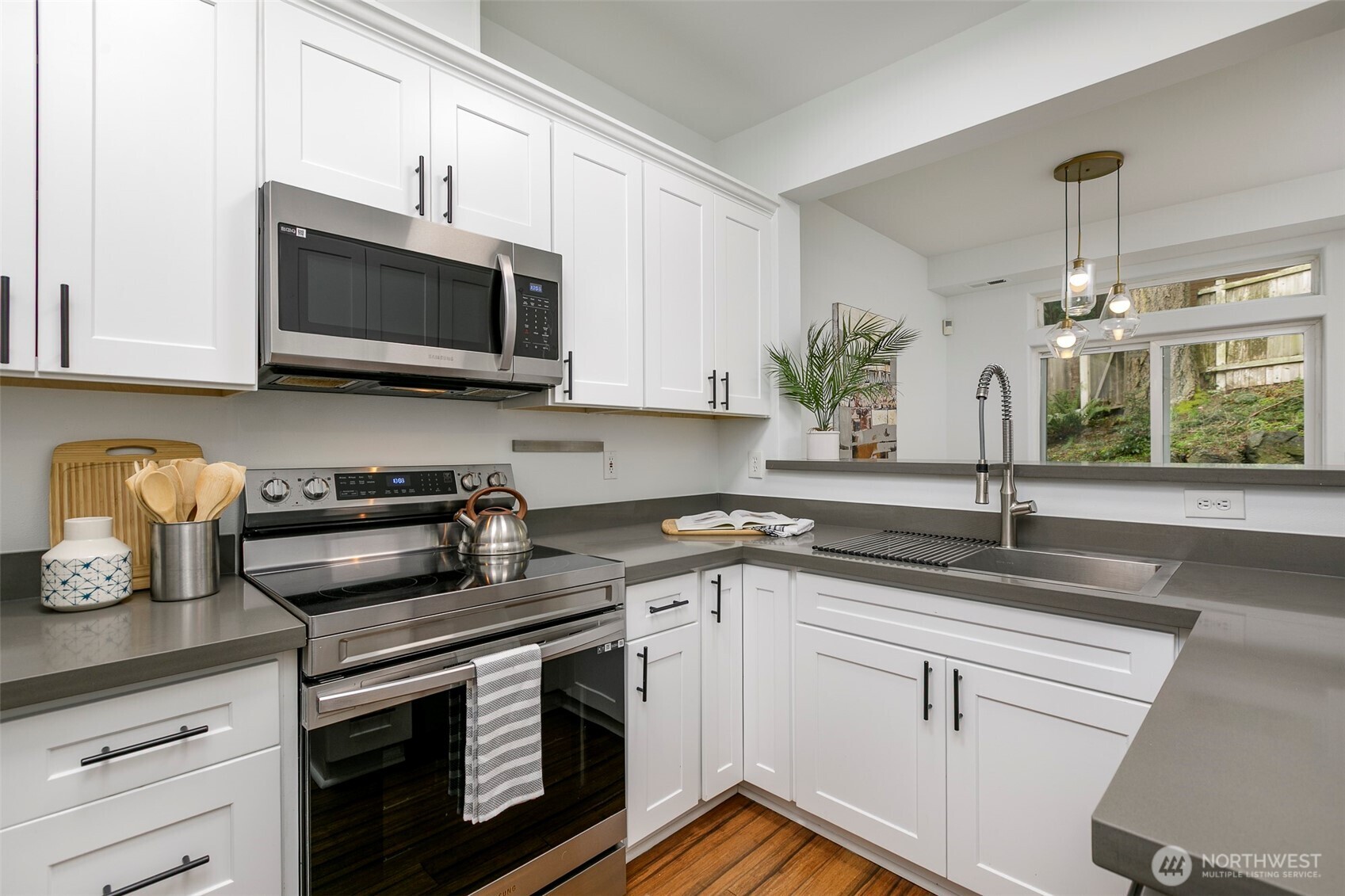 8828 238th Street Southwest, Unit C3 Edmonds, WA 98026 - Photo 13 of 29 a kitchen with granite countertop a sink stainless steel appliances and cabinets