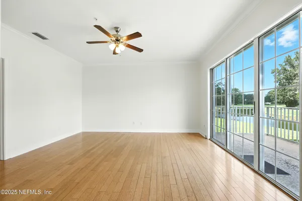 an empty room with window and ceiling fan