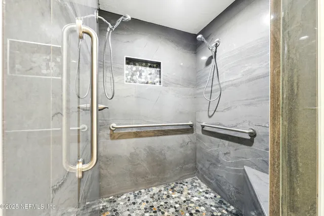 a bathroom with a sink shower and a mirror