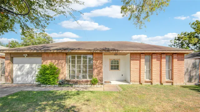 a front view of a house with a garden and yard