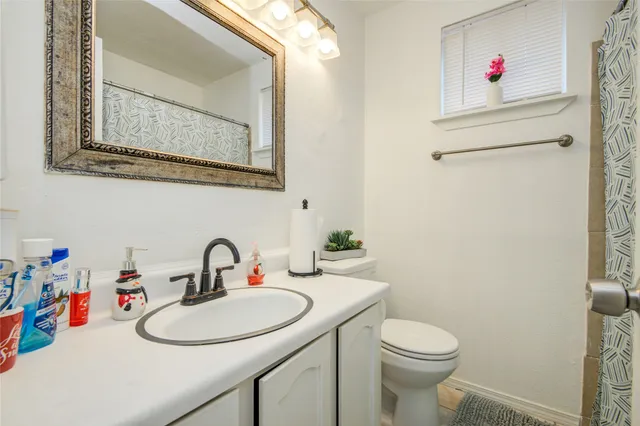 a bathroom with a sink mirror and toilet