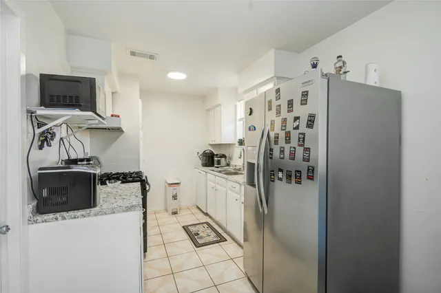 a kitchen with stainless steel appliances a refrigerator and a stove top oven