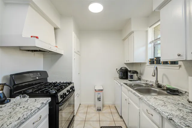 a kitchen with a sink stove top oven and cabinets