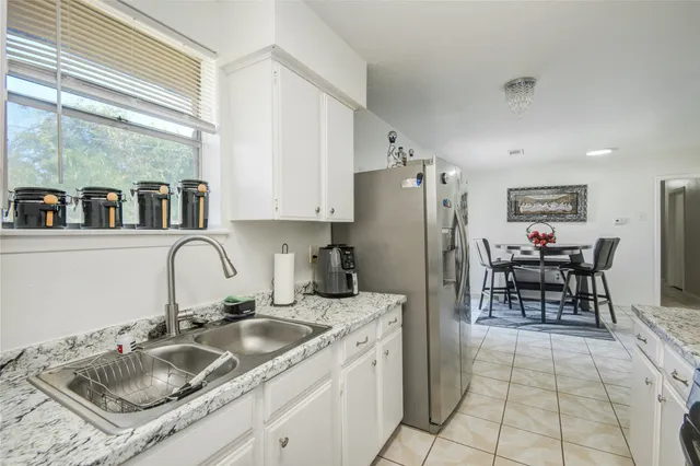 a kitchen with granite countertop a sink stainless steel appliances and cabinets