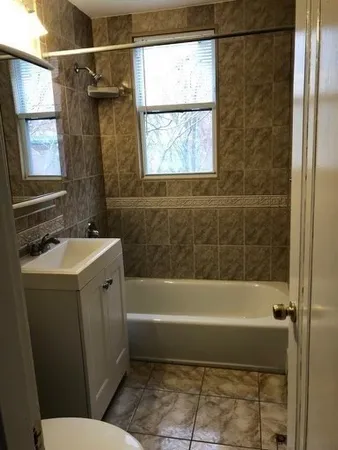 a bathroom with a sink a window and a shower