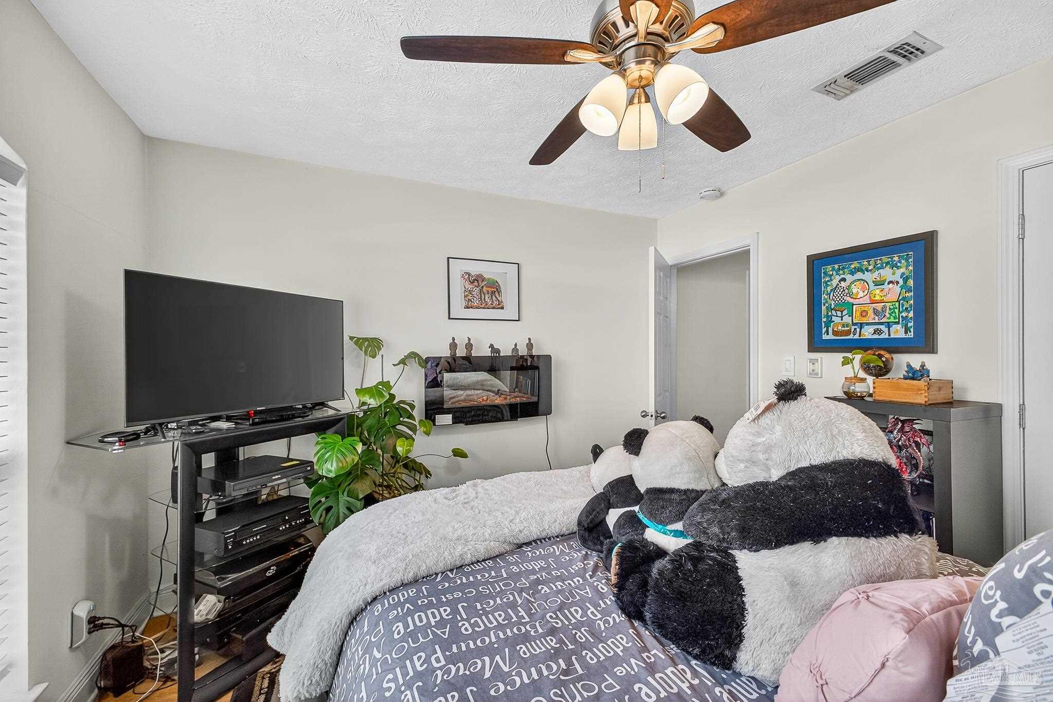 10051 Bristol Park Road Cantonment, FL 32533 - Photo 44 of 60 a bedroom with a bed and a flat screen tv