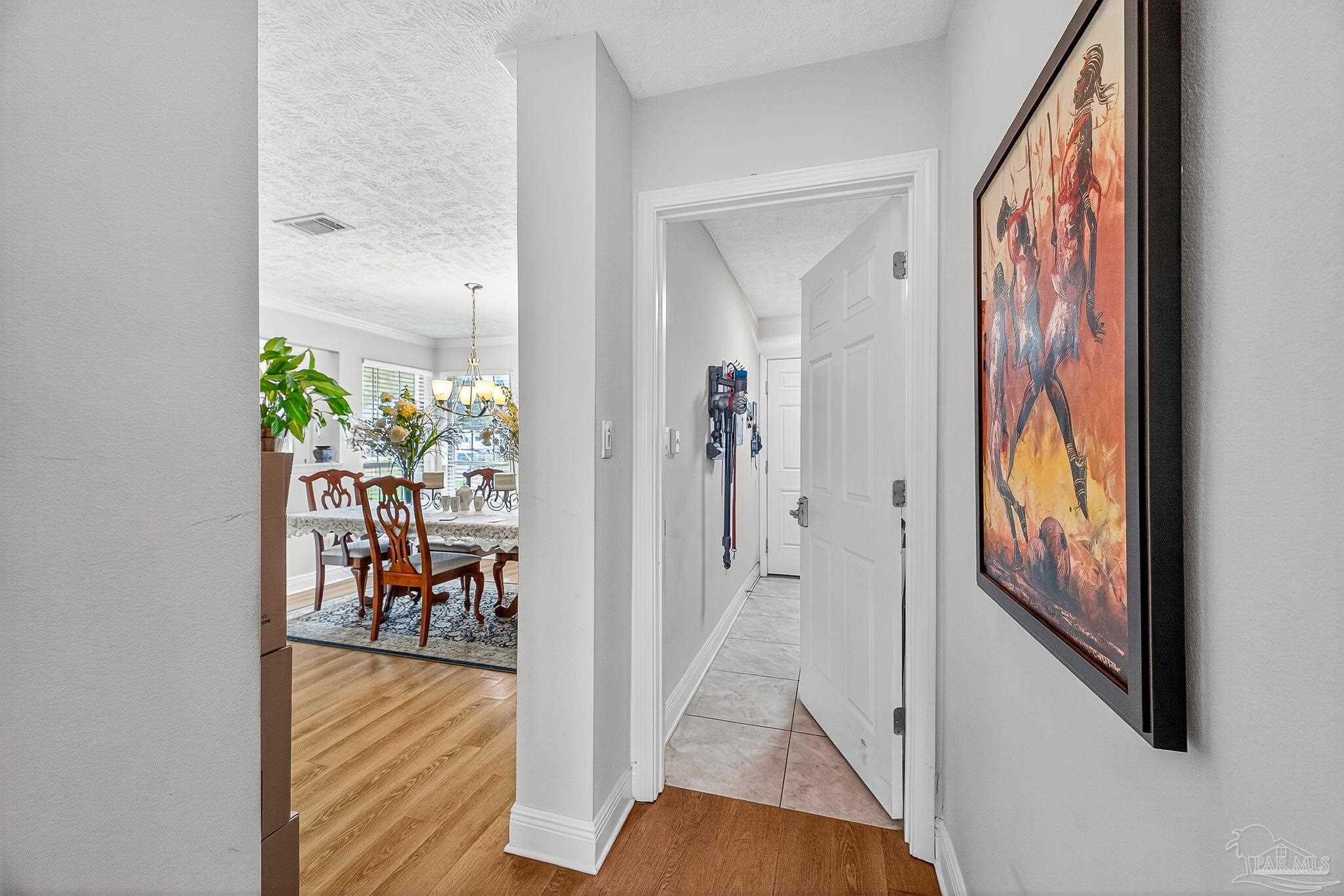 10051 Bristol Park Road Cantonment, FL 32533 - Photo 56 of 60 hallway view with wooden floor and dining room view