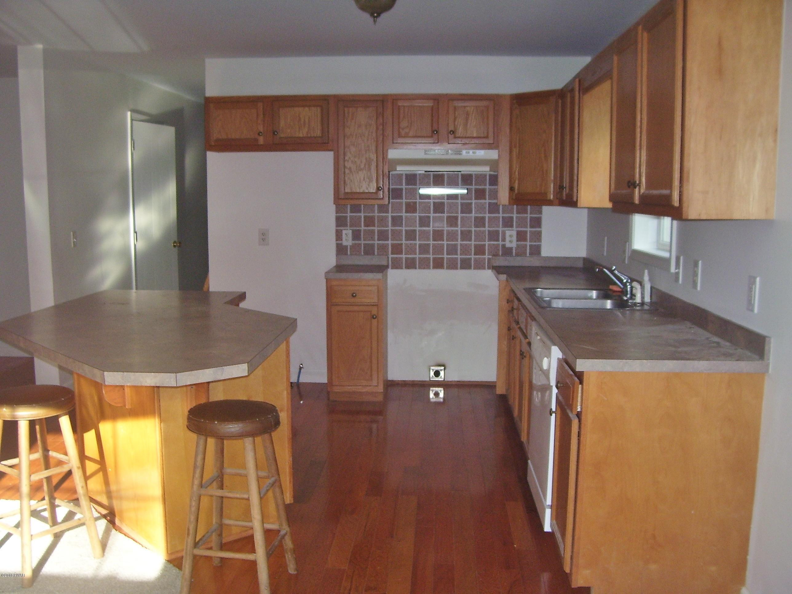 13 W Road Hawley, PA 18428 - Photo 6 of 26 a kitchen with a sink a stove and cabinets