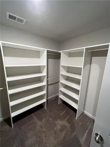 a view of walk in closet with empty racks
