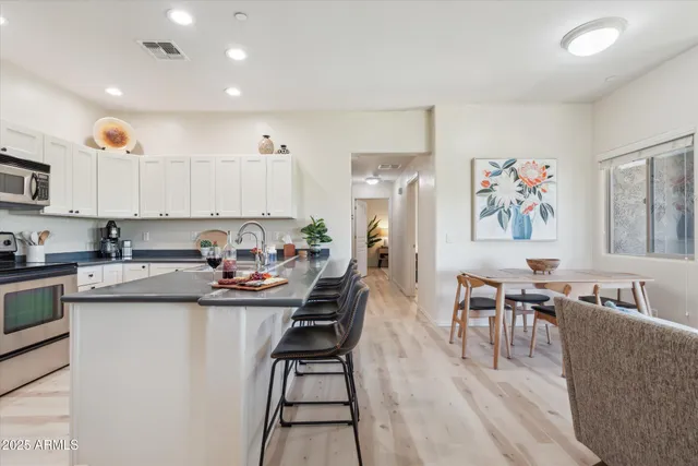 a view of kitchen with stainless steel appliances granite countertop dining room and wooden floor