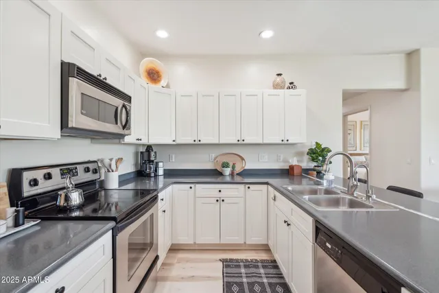 a kitchen with stainless steel appliances granite countertop a sink stove and cabinets