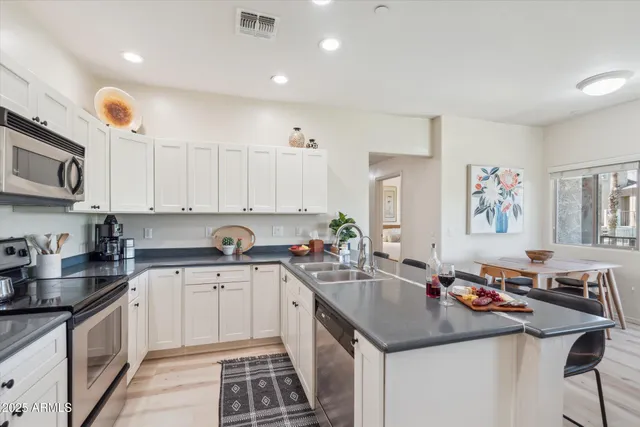 a kitchen with a sink stove top oven and cabinets