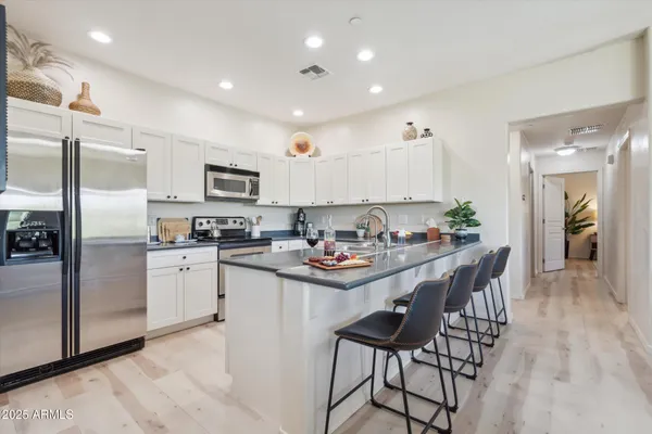 a kitchen with stainless steel appliances kitchen island granite countertop a sink and cabinets