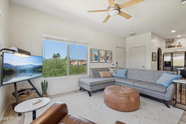 a living room with furniture and a view of kitchen