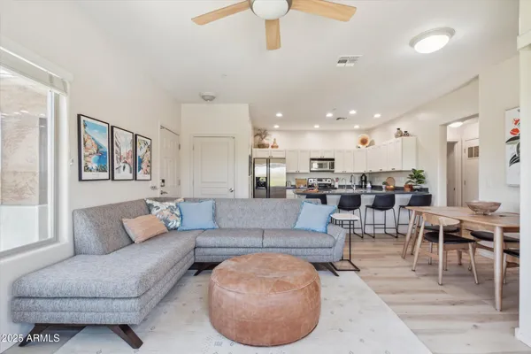 a living room with furniture and a view of kitchen