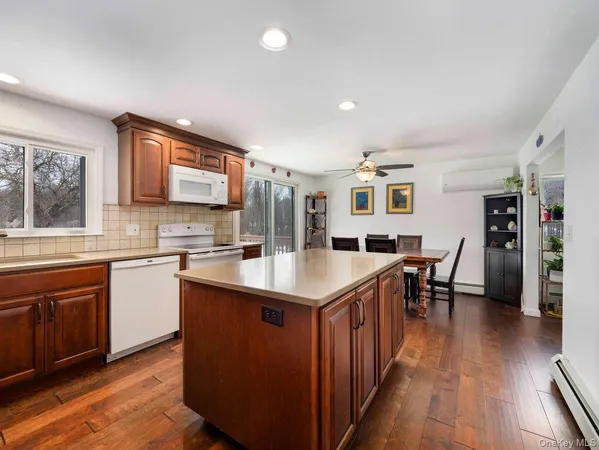 a kitchen with stainless steel appliances granite countertop a table chairs sink and cabinets