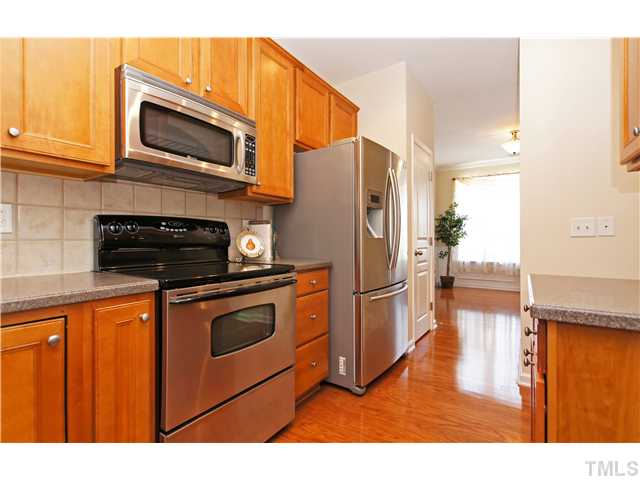 7848 Spungold Street Raleigh, NC 27617 - Photo 5 of 21 a kitchen with stainless steel appliances granite countertop a refrigerator microwave and stove top oven
