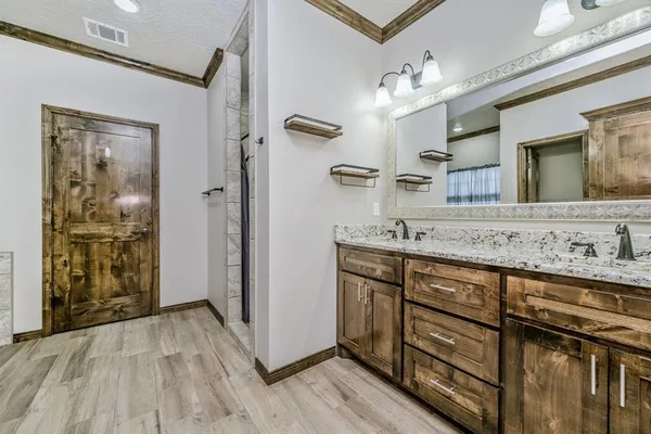 a spacious bathroom with a granite countertop sink mirror and shower