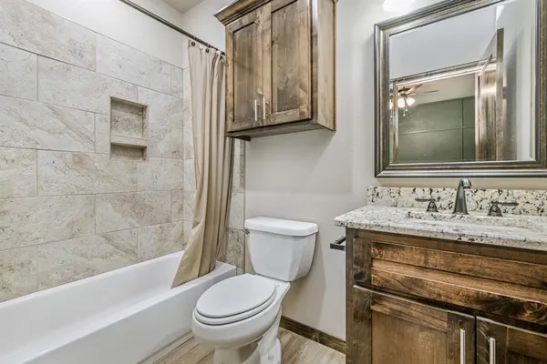a bathroom with a granite countertop sink toilet and shower