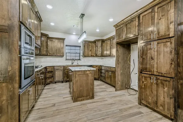 a kitchen with stainless steel appliances a refrigerator sink and cabinets