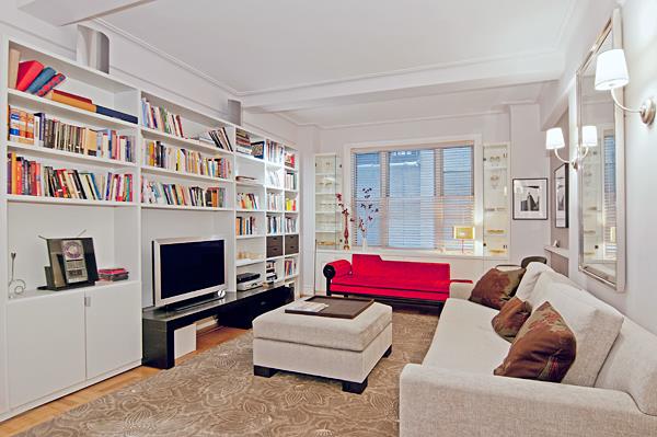 a living room with furniture a flat screen tv and a bookshelf