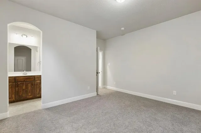 an empty room with a sink and mirror