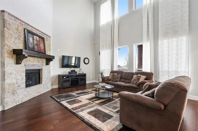 a living room with furniture a flat screen tv and a fireplace
